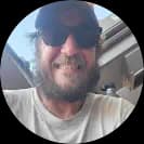 Smiling bearded man wearing sunglasses and a hat