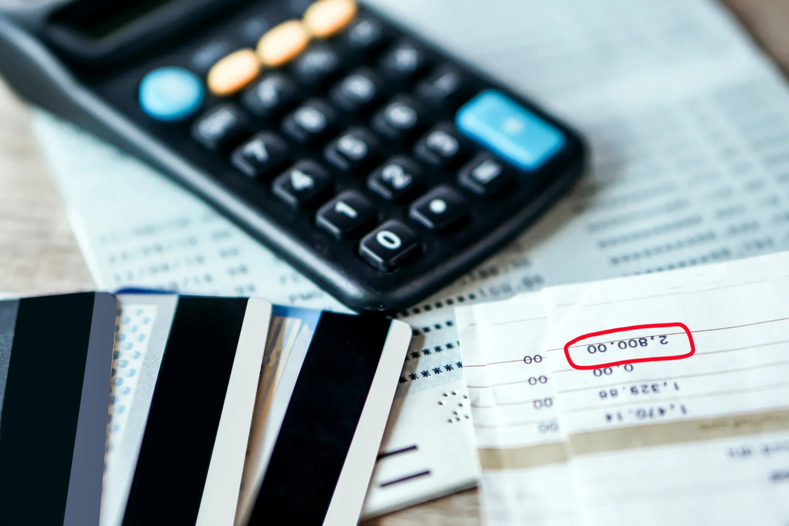 A calculator on top of bills and credit cards